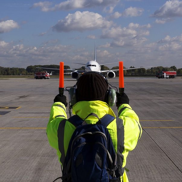 A Supervisor Helps At The Aircraft Parking At The Airport